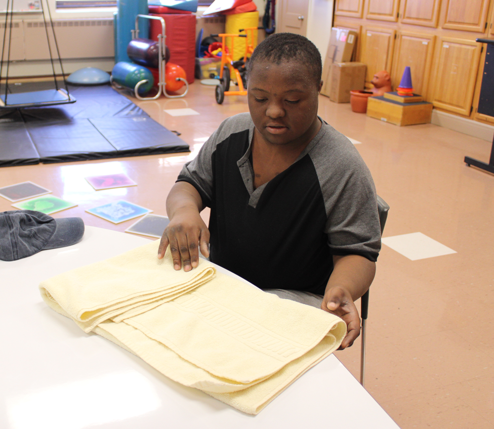 Folding-Laundry-2 student learning to fold laundry