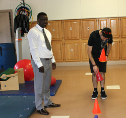 faculty and student setting up a physical therapy session
