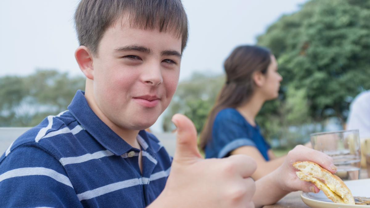 autistic boy giving a thumbs up positive